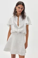 Minifalda blanca de lino con silueta evasé, tiro alto y cierre trasero oculto.