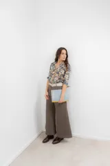 Pantalón de corte wide leg en color marrón, con tiro medio, cierre frontal con botón metálico y costuras visibles a contratono.