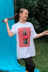 Remerón de algodón blanco con corte oversize y cuello redondo, que presenta un estampado frontal con diseño de una lata de sardinas sobre fondo de rayas.