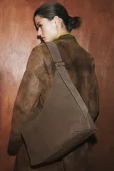 Bolso de hombro tipo maxi saca de piel color marrón verdoso, con asa de hombro ajustable con anilla metálica y cierre interno de imán.