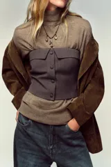 Top bustier corsetero color gris oscuro, con escote recto, solapa y hombros descubiertos. Presenta falsos botones forrados a tono en el frente y cierre lateral con cremallera oculta.