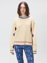 Sweater de punto con diseño de ochos, cuello redondo y detalles en contraste. Presenta rombos de colores en las mangas y franjas en el cuello, puños y ruedo.