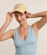 Gorra de sarga amarilla con visera curva, ajuste trasero y bordado frontal con texto y diseño de concha marina.