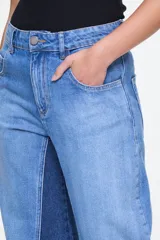 Pantalón de denim bicolor de tiro alto, corte amplio, diseño de cinco bolsillos y combinación de paneles en tonos de azul.