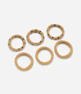 Pack de seis gomitas elásticas para el pelo, de tamaño mediano y sin costuras. El set incluye tres unidades lisas en color beige y tres unidades estampadas con lunares negros sobre base beige.