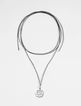 Collar largo de cordón negro con dije metálico plateado en forma de espiral texturizada.