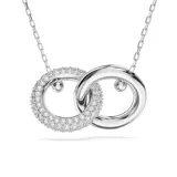 Colgante con cadena plateada y dos aros entrelazados, uno plateado liso y otro plateado con pavé de cristales blancos.