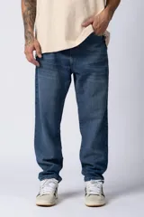 Jean de corte mom fit con diseño holgado y estilo vintage, confeccionado en denim de tono azul medio con acabado lavado.