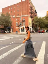 Falda larga negra con diseño de caderín y tablas.