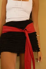 Faja ancha de cuero ovino color bordó, anudada al frente con un gran lazo.