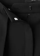 Pantalón de vestir negro de tiro medio con diseño wide leg, detalle de pinzas frontales, bolsillos laterales y cierre delantero con botón, gancho y cremallera ocultos.