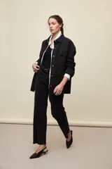 Jeans de corte straight y tiro medio, color negro, confeccionados en denim con spandex. Presenta un sutil tajo en la parte inferior del ruedo.
