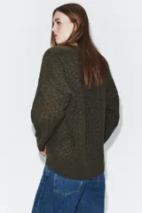 Jersey de punto con diseño de ochos, cuello en pico y manga larga, de corte oversize.