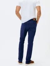 Pantalón de jean corte skinny, color azul medio, con diseño de cinco bolsillos y cierre frontal con botón y cremallera.