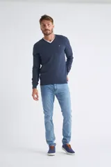 Sweater de tejido de punto color beige, con escote en V, mangas largas y puños y dobladillo acanalados. Presenta un pequeño logo bordado en el pecho.