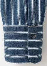 Camisa oversize de algodón estilo denim, de color azul con estampado de rayas, cuello camisero, manga larga con puños abotonados, bolsillo de parche en el pecho y cierre frontal con botones.