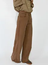 Pantalon de corte recto y tiro medio, confeccionado en gabardina color marrón. Presenta cierre frontal con botón y bolsillos laterales.