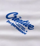 Remera de algodón color blanco tiza, manga corta y cuello redondo. Presenta un estampado grande en la espalda con la palabra "Creative" en tipografía cursiva iridiscente, un oso de goma con efecto holográfico en tonos azules y rosados, y el texto "MATTERS MORE THAN P¡FORMACE" debajo.