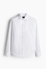 Camisa de algodón blanca con cuello italiano, cierre frontal de botones y mangas largas con puños ajustables. Corte entallado Slim Fit.