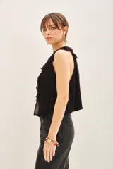 Top negro sin mangas con escote profundo, detalle de volados frontales y lazos para anudar en el cuello.