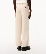 Pantalón de vestir beige de corte wide leg, con trabillas para cinto, bolsillos y diseño de sastrería.
