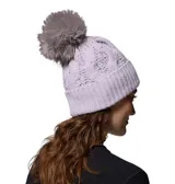 Gorro de lana tejido con diseño de ochos, color lavanda, con pompón de pelo sintético en tono tostado y detalle de placa metálica con logo de la marca.