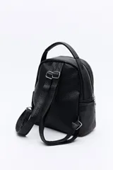 Mochila negra de cuero sintético texturizado, con doble compartimento principal con cierre metálico, bolsillos laterales y manija superior. Incluye correas regulables.