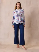 Blusa de gasa estampada con flores, marca Zac & Rachel. Tiene cuello a la base con abertura central con botones y mangas largas abullonadas.