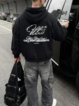 Hoodie negro con capucha, de corte oversize y confección en felpa, con estampa metalizada y gráfica en la espalda.