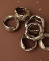 Anillo plateado de bronce, alpaca y plata 925, con forma irregular y textura rústica.