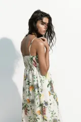 Vestido midi de color blanco con estampado botánico de frutas y flores, escote cuadrado, breteles finos y falda con vuelo.