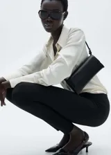 Pantalon slim fit de tejido de punto con cintura elástica, costuras frontales decorativas y cierre con cremallera en los bajos.