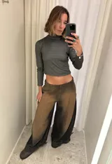 Jean de corte wide leg con efecto degradado en tonos marrón y negro. Presenta costuras verticales frontales y un diseño de puño ajustable en el bajo de la pierna.