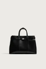 Bolso de mano estructurado en color negro, con diseño minimalista y detalle de cinturón decorativo en la parte superior. Cuenta con doble asa de mano y cierre magnético.