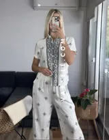 Conjunto de camisa de manga corta con cuello y pantalón largo de corte palazzo, ambos con estampado geométrico en blanco y negro.