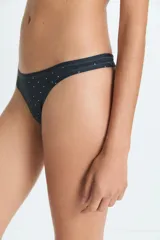 Bombacha tipo colaless de color negro con estampado de pequeños puntos blancos, confeccionada en poliamida y elastano con forro de algodón.