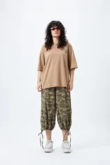 Remera negra de corte holgado con mangas cortas amplias y cuello redondo. Estampado pequeño de flor en el pecho y estampado grande en la espalda con diseño floral y texto.