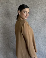 Remera color tostado de manga larga, con cuello polo y botones frontales.