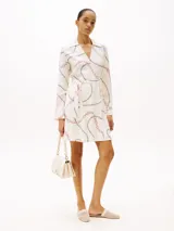 Minivestido cruzado de viscosa color crema con estampado de cadenas en negro y rosa, cuello en V y cinturón anudable.