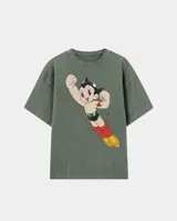 Remera de algodón con efecto stone wash en color verde oliva, de corte oversize. Presenta un estampado frontal del personaje Astroboy volando con la frase 'en un viaje astral'.