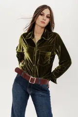 Camisa verde oliva de terciopelo con corte estilo jean, bolsillo en la parte delantera y botones símil metal color oro viejo.