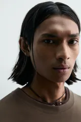 Camiseta de manga corta y cuello redondo, color marrón oscuro, con estampado frontal que dice "BOWERY ELECTRIC" en tipografía desgastada.