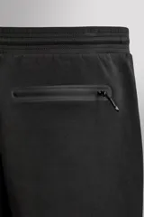 Pantalón jogger relaxed fit Zara Athleticz de tejido técnico compacto elástico con mezcla de algodón. Presenta cintura elástica ajustable con cordón, bolsillos laterales en la cadera, bolsillo trasero con cierre de cremallera, bajo ajustable con elástico y detalle de logo estampado en la pernera.