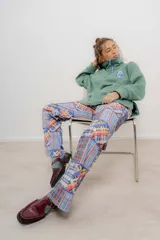 Buzo verde con cierre metálico, cuello alto y bordados.