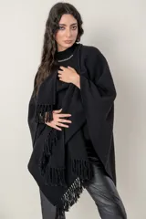 Ruana de punto color negro, modelo Esteña, con diseño abierto y terminación de flecos en los bordes.
