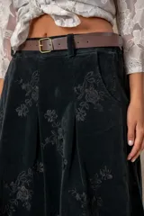 Pollera larga de pana color chocolate, con diseño de tablas frontales y bordados florales en toda la superficie. Cuenta con cintura con pasacintos.