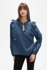 Blusa de jean con volados frontales, cuello redondo con abertura en V y lazo para anudar, y mangas largas con puños elásticos.
