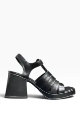 Sandalias de cuero negro con plataforma delantera, taco ancho geométrico, tiras cruzadas en el empeine y tira ajustable en el talón.