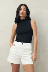 Short de tiro medio y calce ajustado, color blanco, con dobladillos en las piernas y cierre frontal con botón.