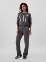 Pantalón deportivo de corte recto y tiro medio, color gris oscuro, con logo de la marca estampado en la parte superior delantera.